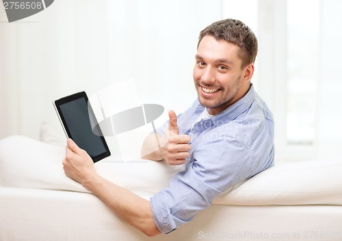 Image of smiling man working with tablet pc at home