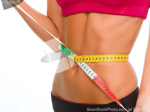 Image of close up of trained belly with measuring tape
