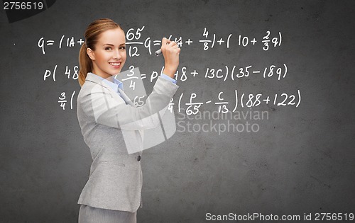 Image of businesswoman writing formula with marker