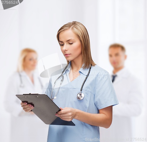 Image of smiling female doctor or nurse with clipboard