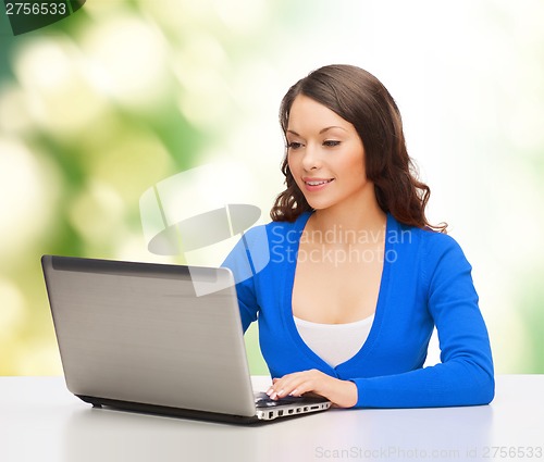 Image of smiling woman in blue clothes with laptop computer