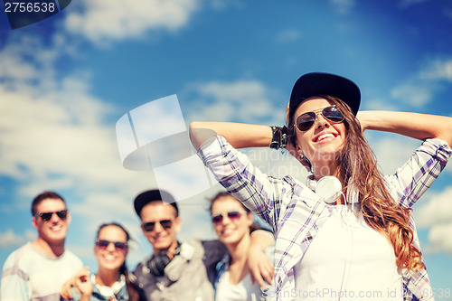 Image of teenage girl with headphones and friends outside