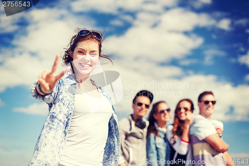 Image of teenage girl with headphones and friends outside