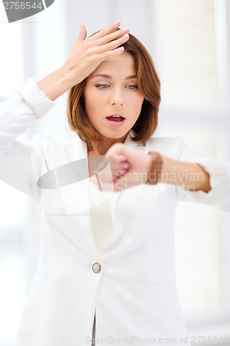 Image of stressed businesswoman looking at wrist watch