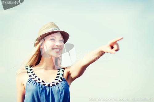 Image of girl in hat showing direction on the beach