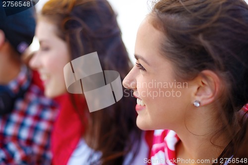 Image of smiling teenage girl outdoors with friends