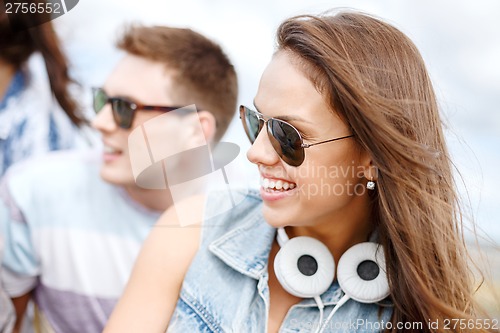 Image of smiling teenage girl outdoors with friends
