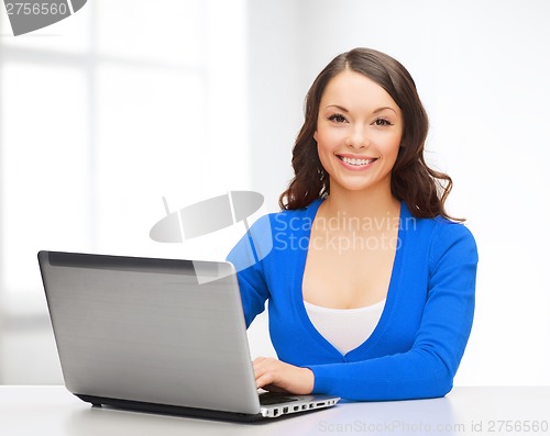 Image of smiling woman in blue clothes with laptop computer