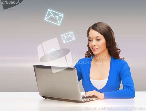 Image of smiling woman in blue clothes with laptop computer