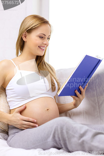 Image of pregnant woman reading book at home