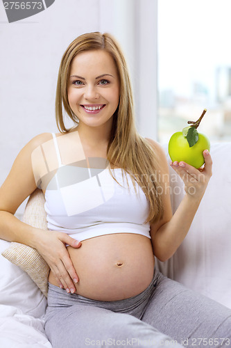 Image of happy pregnant woman with fresh green apple