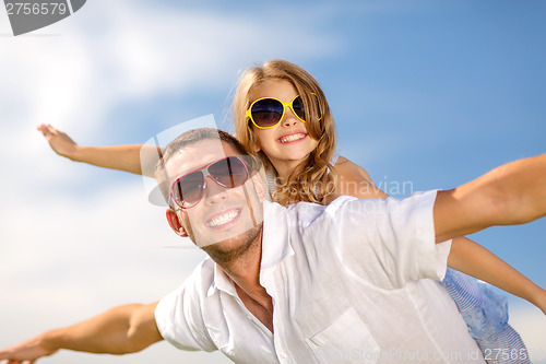 Image of happy father and child in sunglasses over blue sky