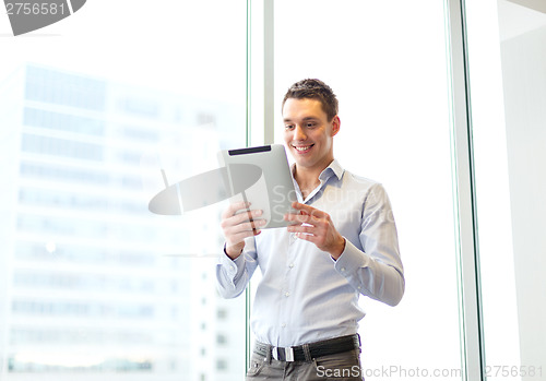 Image of smiling businessman with tablet pc in office