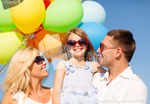 Image of happy family with colorful balloons outdoors