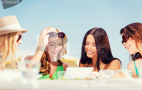 Image of girls looking at tablet pc in cafe
