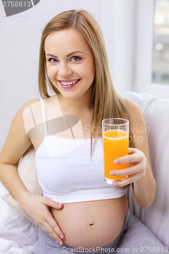 Image of happy pregnant woman with fresh orange juice