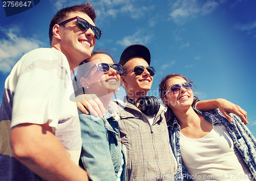 Image of smiling teenagers in sunglasses hanging outside