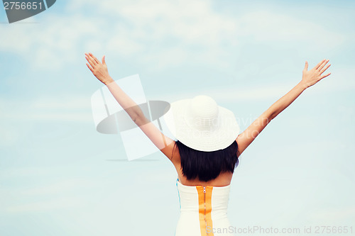 Image of girl with hands up on the beach