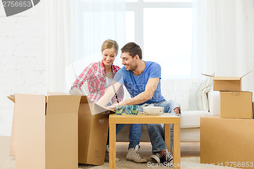 Image of smiling couple unpacking kitchenware