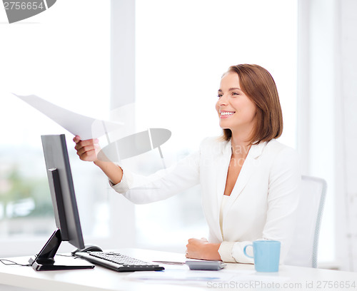 Image of sming businesswoman giving papers in office