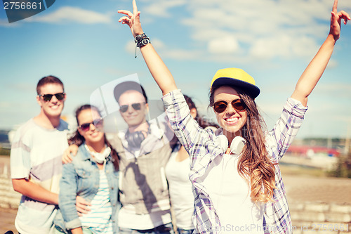 Image of teenage girl with headphones and friends outside