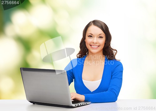 Image of smiling woman in blue clothes with laptop computer
