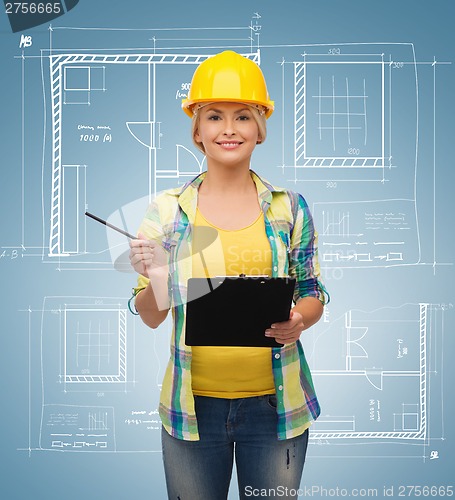 Image of smiling woman in helmet with clipboard