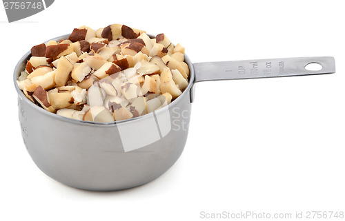 Image of Chopped brazil nuts in a metal cup measure