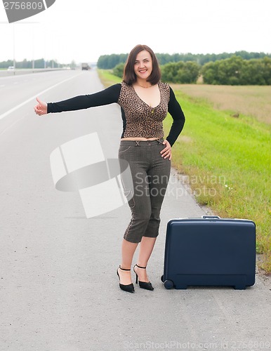 Image of Woman with suitcase on road