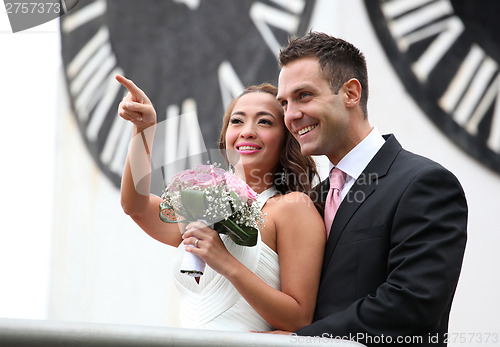 Image of Young wedding couple showing