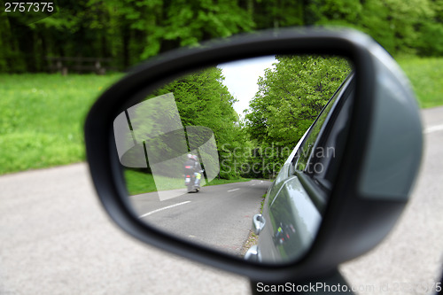 Image of forest road reflection,  rearview car driving mirror view green 