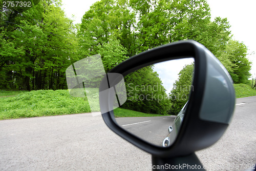 Image of forest road reflection,  rearview car driving mirror view green 