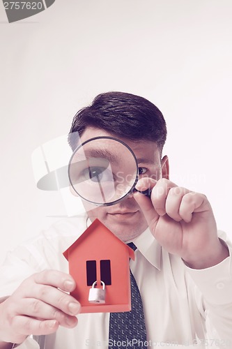 Image of Man with magnifying glass house and paper