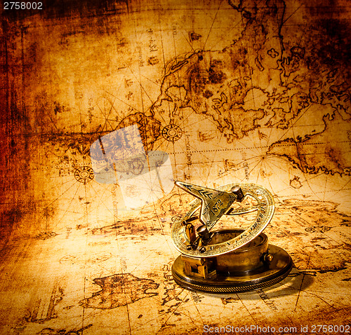 Image of Vintage compass lies on an ancient world map.