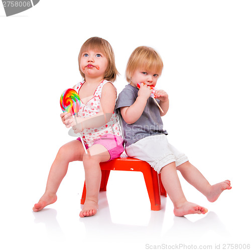 Image of Babies eating a sticky lollipop