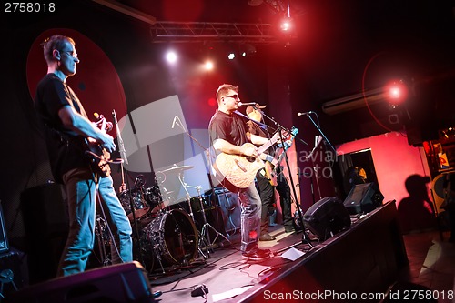 Image of Band performs on stage in a nightclub