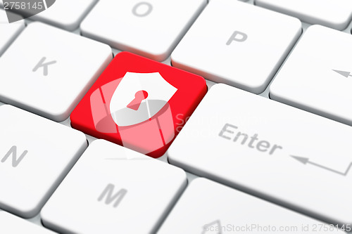 Image of Protection concept: Shield With Keyhole on computer keyboard bac