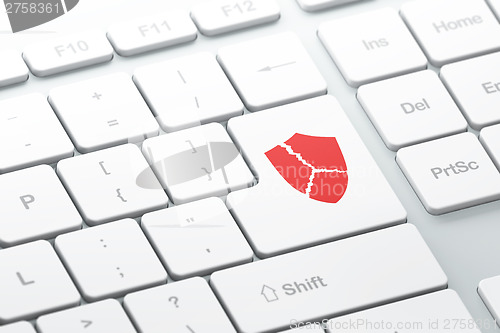 Image of Security concept: Broken Shield on computer keyboard background