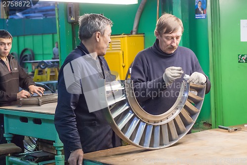 Image of Mechanics assembles turbine for aviation engine