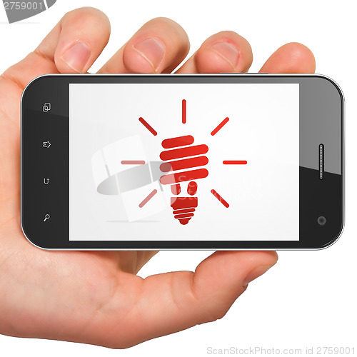 Image of Finance concept: Energy Saving Lamp on smartphone