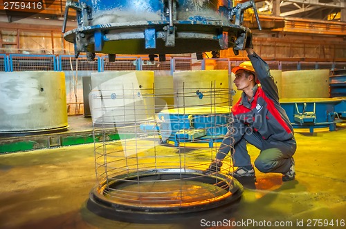 Image of Worker controls process of making circle block