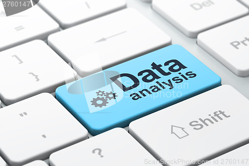 Image of Information concept: Gears and Data Analysis on computer keyboar