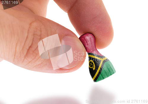 Image of Hand holding wooden pawn, flag painting, selective focus