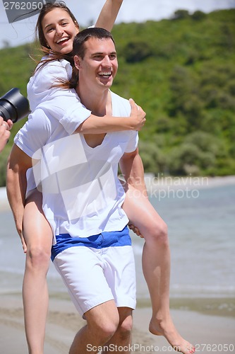 Image of happy couple have fun on the beach