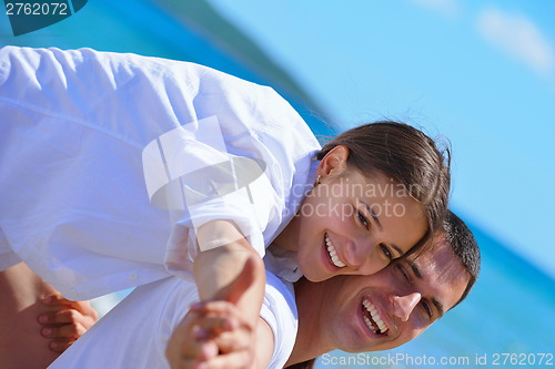 Image of happy couple have fun on the beach