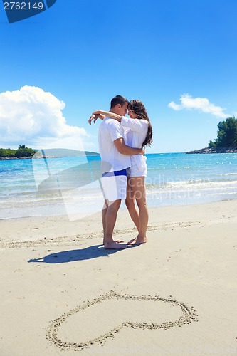 Image of romantic  couple in love  have fun on the beach with heart drawi