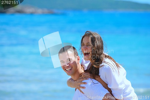 Image of happy couple have fun on the beach