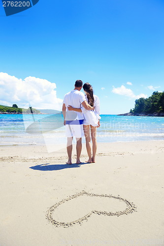 Image of romantic  couple in love  have fun on the beach with heart drawi
