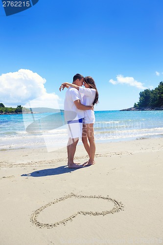 Image of romantic  couple in love  have fun on the beach with heart drawi