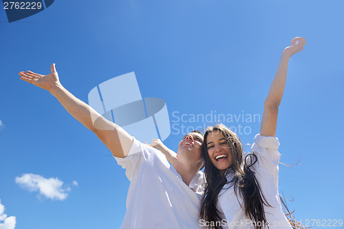 Image of happy couple have fun on the beach